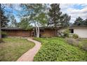 Charming brick home with a well-manicured lawn and a brick pathway leading to the entrance at 3285 Balsam St, Wheat Ridge, CO 80033