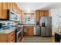 Well-lit kitchen featuring stainless steel appliances, tile flooring, and ample cabinet space at 1492 S Cathay St, Aurora, CO 80017