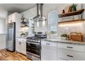 Bright kitchen features white cabinets, stainless steel appliances, and sleek countertops at 265 Upper Glenway, Palmer Lake, CO 80133