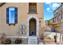 Close-up of the front entrance with a unique stone archway, house number, and blue shuttered window at 10546 Graymont Ln # D, Highlands Ranch, CO 80126