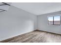 This bedroom features wood floors, a neutral wall color, and a bright window offering ample light at 2929 W Floyd Ave # 217, Denver, CO 80236