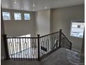 Spacious living area with a modern staircase, contemporary railing, high ceilings, and abundant natural light at 5591 Farrier Pt, Castle Rock, CO 80104