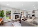 Cozy living room with a modern fireplace, large window, and an open view into the updated kitchen at 2477 S Dover Way, Lakewood, CO 80227