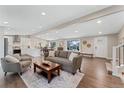 Bright, open-concept living room with hardwood floors and a seamless flow into the kitchen and dining area at 2477 S Dover Way, Lakewood, CO 80227