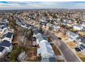 Expansive aerial view of a suburban neighborhood showcasing neatly arranged homes, tree-lined streets, and distant city skyline at 9749 Newcastle Dr, Highlands Ranch, CO 80130
