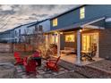Inviting backyard with a cozy fire pit, red Adirondack chairs, and a covered patio area for outdoor relaxation and entertainment at 9749 Newcastle Dr, Highlands Ranch, CO 80130