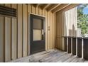 Close-up of front door #40 of condo unit with a screen door, vertical siding and wooden deck at 8050 Niwot Rd # 40, Niwot, CO 80503