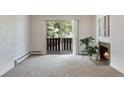 Carpeted living room with fireplace, sliding glass doors to balcony, and bright natural light at 8050 Niwot Rd # 40, Niwot, CO 80503