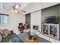 Bright living room with a decorative fireplace, ceiling fan, and tiled floor at 384 S Ironton St # 314, Aurora, CO 80012