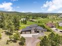 Stunning aerial shot of modern home with lush green spaces and serene mountain views at 3630 Mesa Verde Rd, Monument, CO 80132