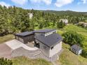 An aerial view of a modern home nestled in a lush, green, hillside community at 3630 Mesa Verde Rd, Monument, CO 80132