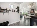 Bright living room with high ceilings, wood floors, stone fireplace, and open layout leading to the kitchen and outdoor views at 3630 Mesa Verde Rd, Monument, CO 80132