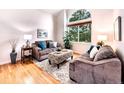 Bright living room featuring vaulted ceiling, hardwood floors, and large windows at 4892 S Robb St, Littleton, CO 80127