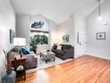Bright living room featuring vaulted ceiling, hardwood floors, and large windows at 4892 S Robb St, Littleton, CO 80127