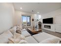 Comfortable living room with a large sectional sofa, fireplace, and natural light from a large window at 430 Millwall Cir, Castle Pines, CO 80108