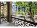 Apartment balcony with an iron railing, offering city views and mature trees at 1210 E Colfax Ave # 302, Denver, CO 80218