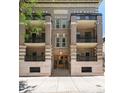 Apartment building exterior featuring balconies with iron railings and intricate brick and stone design at 1210 E Colfax Ave # 302, Denver, CO 80218