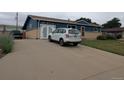 Long concrete driveway leading to a home with a brick and blue exterior, showing ample parking space at 290 W 1St Ave, Broomfield, CO 80020