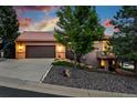 Inviting home with a two-car garage, large driveway, mature landscaping, and charming architectural details at 10751 Fairway Vistas Ct, Littleton, CO 80125