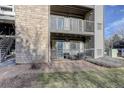 Private patio with seating area, adjacent to a stone wall at 2575 S Syracuse Way # 108, Denver, CO 80231