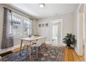 Bright dining room with hardwood floors, a modern table, and large windows at 4326 Batavia Pl, Denver, CO 80220