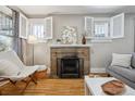 Cozy living room with a brick fireplace, hardwood floors, and bright windows at 4326 Batavia Pl, Denver, CO 80220