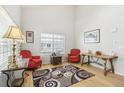 Bright living room with high ceilings, hardwood floors, and ample natural light from large windows at 1440 E 128Th Ct, Thornton, CO 80241