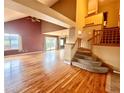 Spacious living room featuring hardwood floors, a staircase, and a sliding glass door at 10064 Westside Cir, Littleton, CO 80125