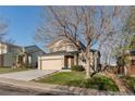Charming two-story home featuring a two-car garage, well-maintained lawn, and mature trees at 2875 S Tower Way, Aurora, CO 80013