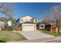 Charming two-story home featuring a two-car garage, well-maintained lawn, and mature trees at 2875 S Tower Way, Aurora, CO 80013