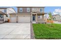 Two-story house with neutral siding, two-car garage, and a landscaped lawn at 13547 Valentia St, Thornton, CO 80602