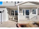 Inviting front porch with white railings and two wicker chairs at 9671 Fox Den Dr, Littleton, CO 80125