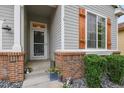 View of the home's front entrance showing a decorative door, gray siding and brick accents at 6471 S Potomac Ct, Englewood, CO 80111