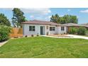 Charming one-story home featuring a lush green lawn, white brick exterior and brown roof at 2230 Niagara St, Denver, CO 80207