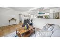 Cozy living space featuring hardwood floors, white walls, a modern coffee table and a comfortable gray sofa at 2230 Niagara St, Denver, CO 80207