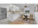 Bright, modern kitchen with white cabinets, stainless steel appliances, and a breakfast nook at 5345 E Thrill Pl, Denver, CO 80207