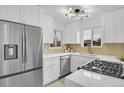 Stylish kitchen features white cabinetry, stainless steel appliances, and ample counter space at 5345 E Thrill Pl, Denver, CO 80207