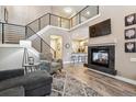 Inviting living room featuring a fireplace, staircase, and open layout to the kitchen at 570 Clarendon Loop, Castle Pines, CO 80108