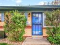 Close up view of the front door with secure screen, brick exterior, and manicured bushes at 4201 Shoshone St, Denver, CO 80211
