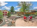 Inviting backyard with a stone patio, lush landscaping, and a charming storage shed at 2170 W Warren Ave, Englewood, CO 80110
