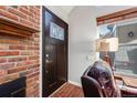 Elegant entryway with a wood door, brick wall accent, and adjacent window at 11710 Elk Head Range Rd, Littleton, CO 80127