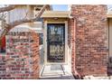 Charming brick facade with secure, decorative iron gate protecting front door at 11710 Elk Head Range Rd, Littleton, CO 80127