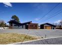 Contemporary home with unique architectural design, gray and brown siding, and a large paved driveway at 8900 W Hampden Ave, Denver, CO 80227