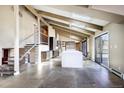 Bright open floor plan with tile flooring, beamed ceilings and quartz kitchen island at 8900 W Hampden Ave, Denver, CO 80227