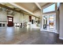 Bright, open living space with vaulted ceilings, fireplace, wood beams and a modern staircase at 8900 W Hampden Ave, Denver, CO 80227