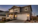 Charming two-story home showcasing a covered porch, two-car garage, stone accents, and manicured landscaping in the front yard at 17203 Birds Foot Ave, Parker, CO 80134