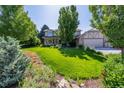Charming two-story home with lush lawn, mature trees, and a spacious two car garage at 1324 Shadow Mountain Dr, Highlands Ranch, CO 80126