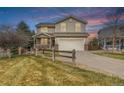 Charming two-story home features a welcoming front porch, two-car garage, and well-maintained lawn at 16523 High Desert Pl, Parker, CO 80134