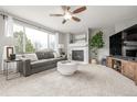 Well-lit living room boasts a fireplace, large windows, and comfortable seating for relaxation and entertainment at 16523 High Desert Pl, Parker, CO 80134