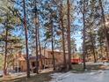 House in a wooded setting with a deck and backyard at 28735 Little Big Horn Dr, Evergreen, CO 80439